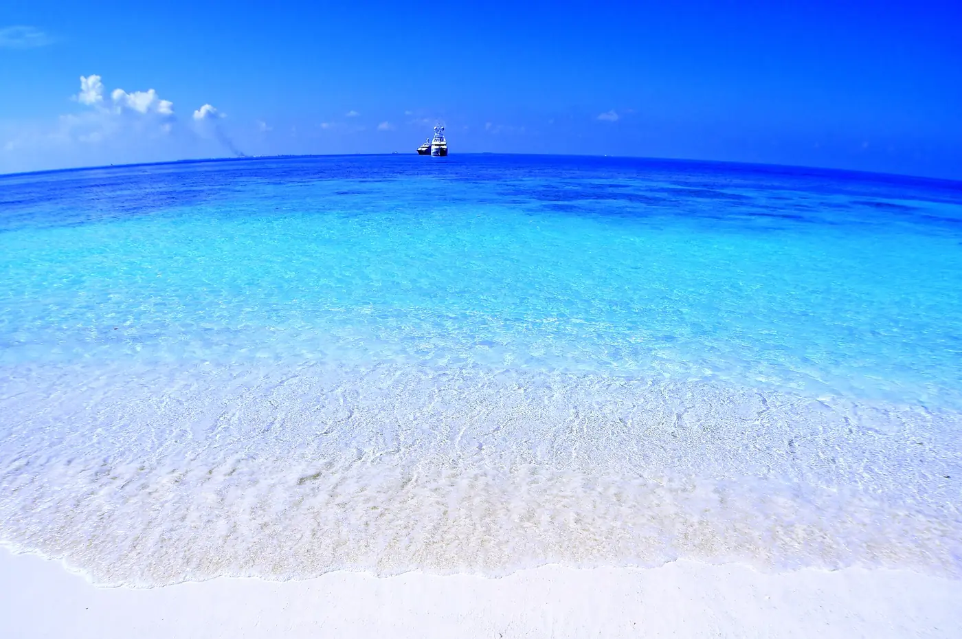 Clear turquoise sea meeting a bright white sandy beach in the Maldives