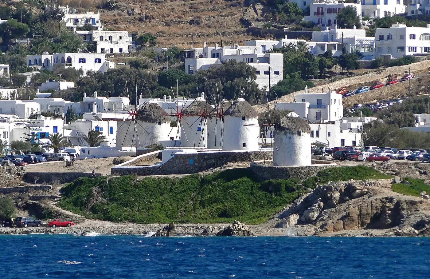 White hillside buildings and windmills above the sea in Mykonos